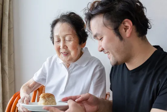 photo grandson sharing rice ball with grandmother